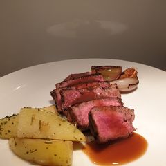 A picture of Eye fillet steak with herb butter potatoes and veggies.
