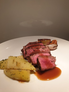 A picture of Eye fillet steak with herb butter potatoes and veggies.