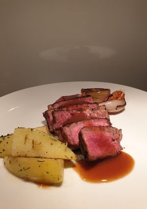 A picture of Eye fillet steak with herb butter potatoes and veggies.