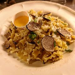 A picture of Truffle pasta served with raw egg yolk.