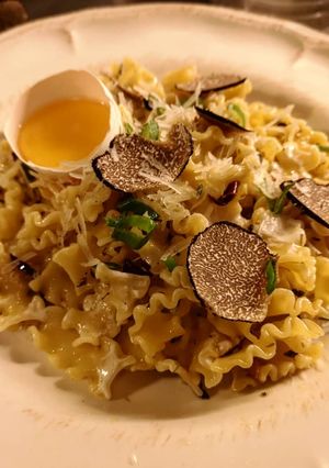 A picture of Truffle pasta served with raw egg yolk.