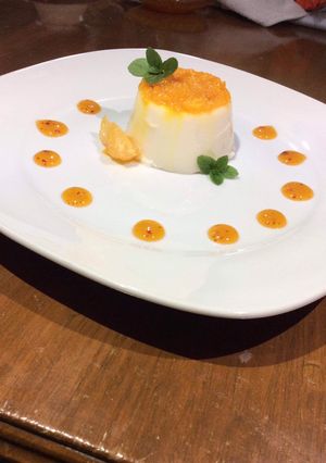 Una foto de Panacotta de coco con salsa de mandarina y mezcal
