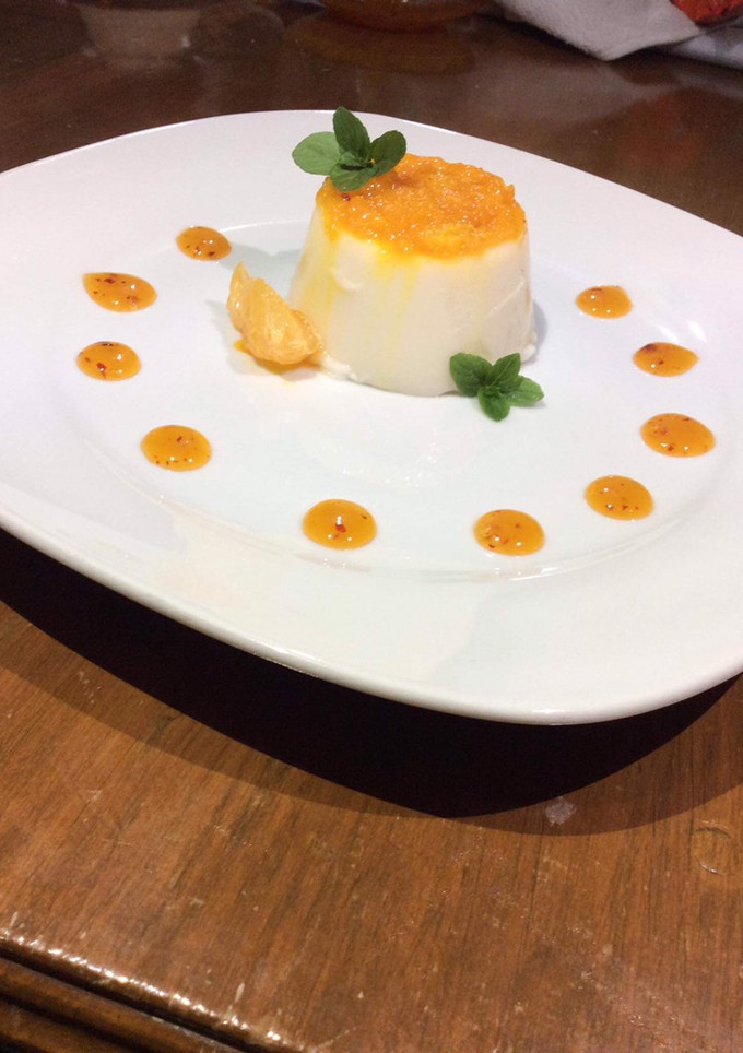 Una foto de Panacotta de coco con salsa de mandarina y mezcal