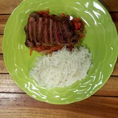 A picture of Sweet and sour peppers, medium rare rib eye and coconut rice.