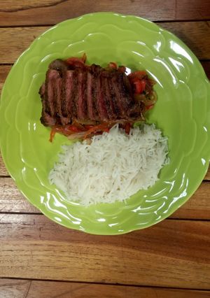 A picture of Sweet and sour peppers, medium rare rib eye and coconut rice.