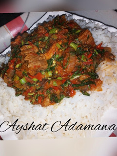 A picture of White rice with spinach sauce.