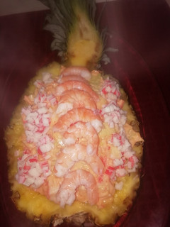 Una foto de Góndola de piña rellena de cóctel de marisco
