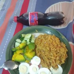 A picture of Jollof rice,boiled egg avacado and cucumber.