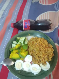 A picture of Jollof rice,boiled egg avacado and cucumber.