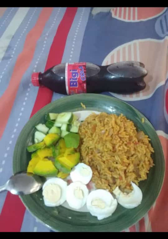 A picture of Jollof rice,boiled egg avacado and cucumber.