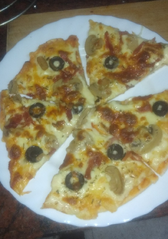 Una foto de Pizza de jamón serrano, champiñones y aceitunas negras