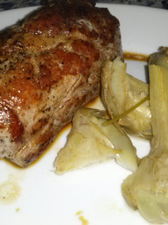 Una foto de Solomillo de cerdo en su jugo con alcachofas tiernas al limón