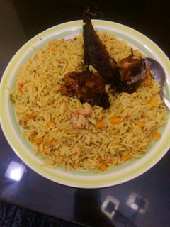 A picture of Jollof rice with prawns,carrots and titus fish.
