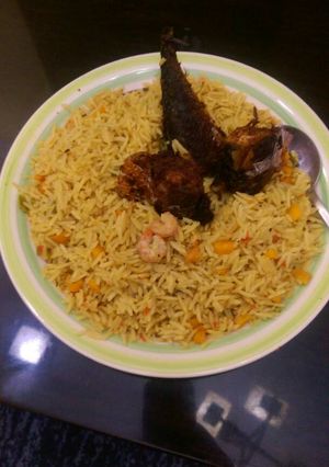 A picture of Jollof rice with prawns,carrots and titus fish.