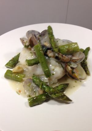 Una foto de Merluza con almejas en salsa verde y espárragos confitados