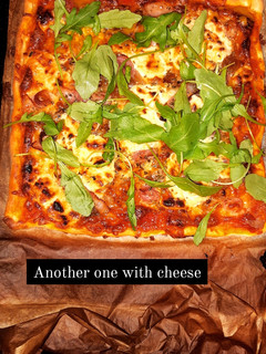 Una foto de Pizza casera con queso de cabra, bacon y rúcula