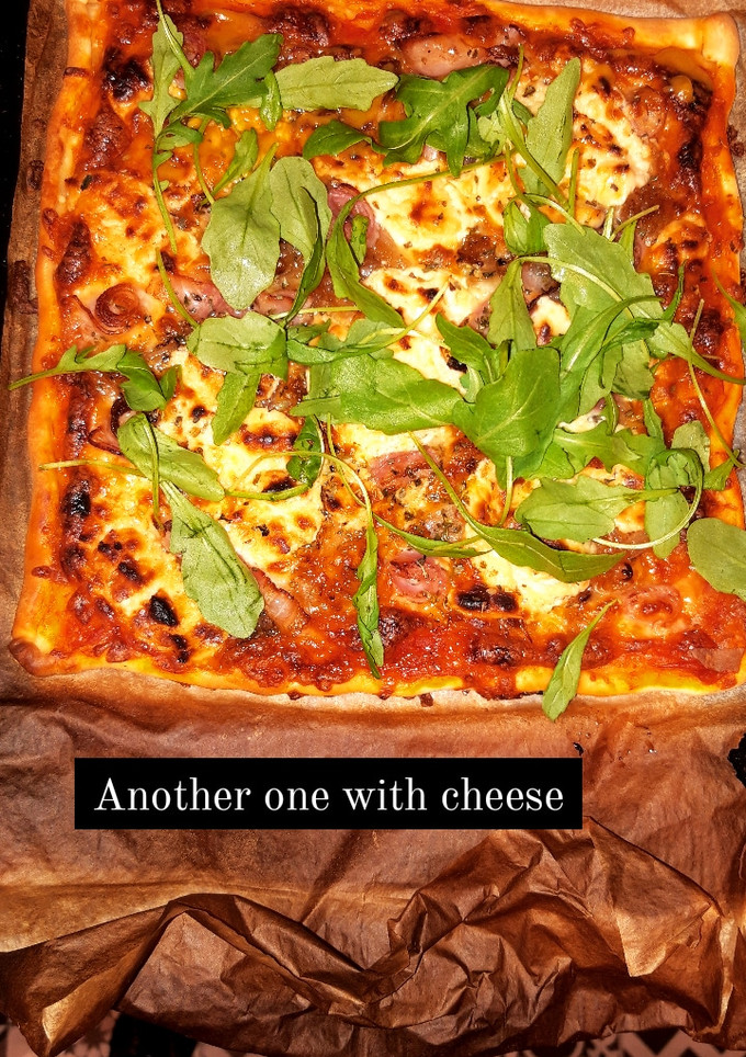 Una foto de Pizza casera con queso de cabra, bacon y rúcula