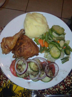 A picture of Mashed potatoes, fried chicken and greens.