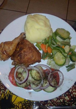 A picture of Mashed potatoes, fried chicken and greens.