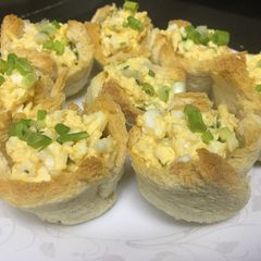 A picture of Egg-cheese salad in bread cups.