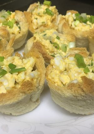 A picture of Egg-cheese salad in bread cups.