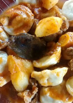 Una foto de Agnelotis de acelga y ricota, con salsa