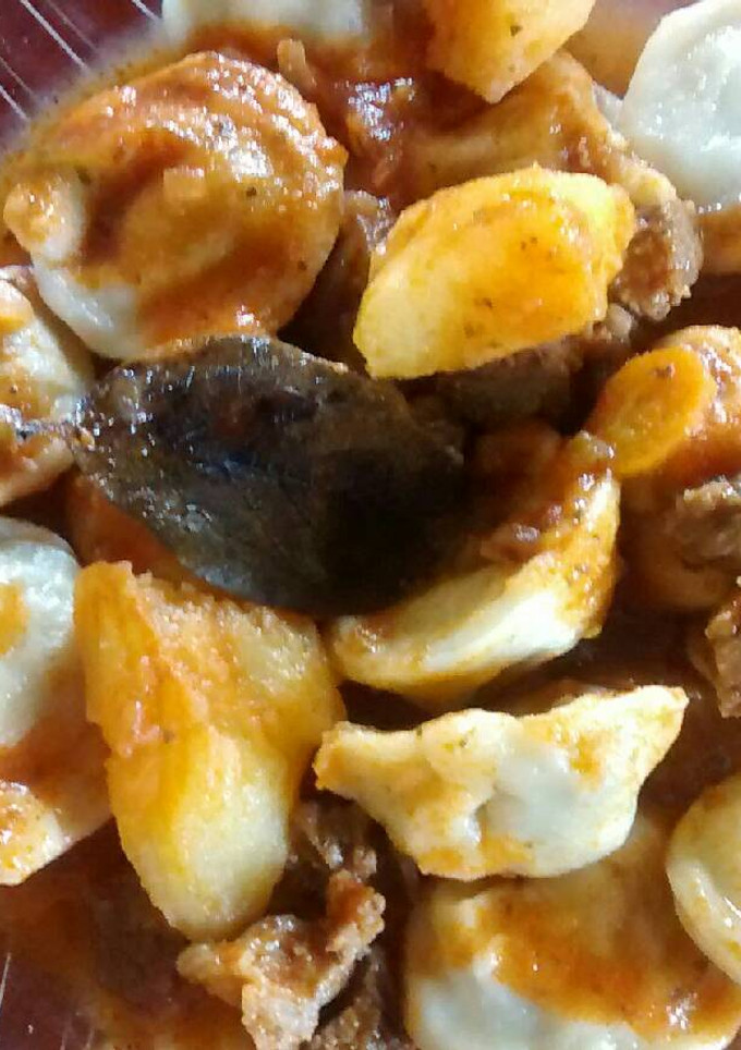 Una foto de Agnelotis de acelga y ricota, con salsa