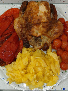 Una foto de Picantón y tomatitos asados con pimientos y patatas fritas