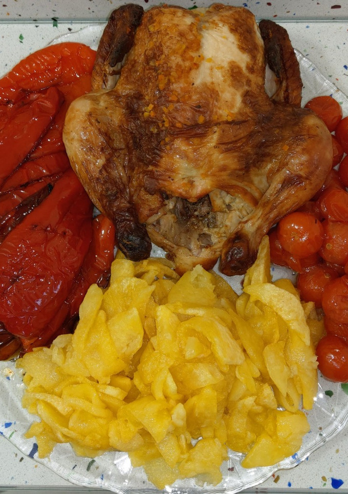 Una foto de Picantón y tomatitos asados con pimientos y patatas fritas