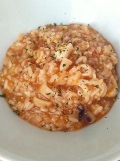 Una foto de Arroz meloso de chipis y merluza
