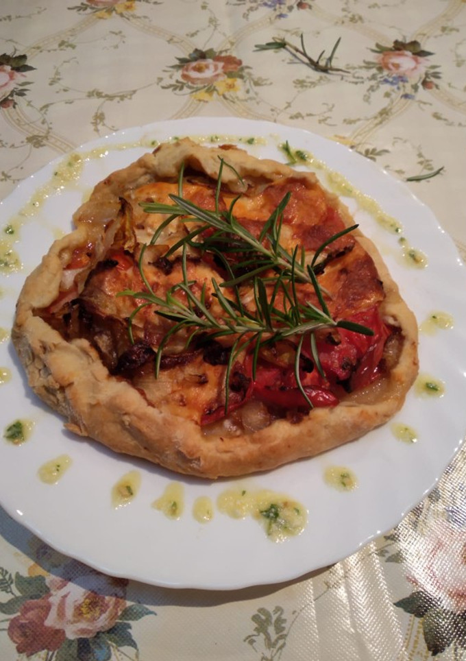 Una foto de Galette de tomate, queso y cebolla con pesto de perejil