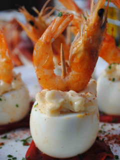 Una foto de Huevos de codorniz rellenos de langostino, sobre pimientos del piquillo, con mahonesa de all i oli