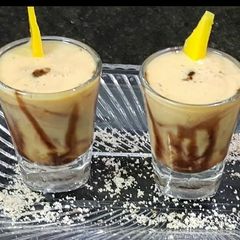 A picture of Mango milkshake shots with chocolate syrup.