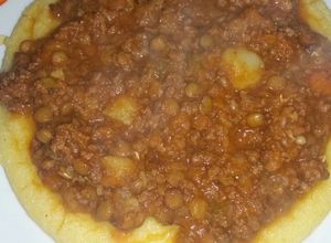 Una foto de Polenta con salsa y lentejas