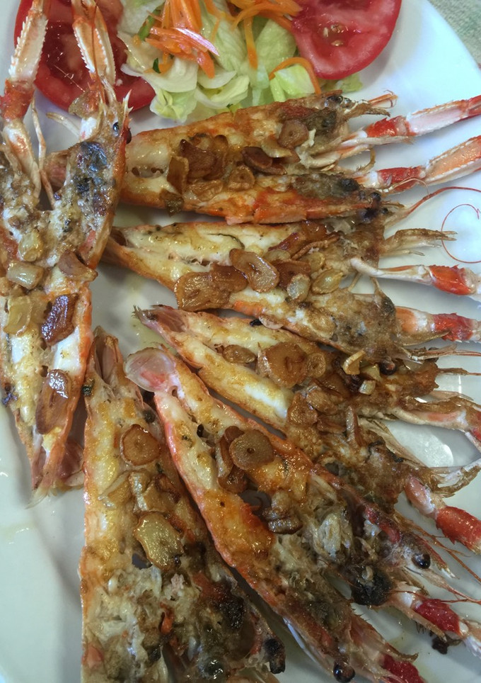 Una foto de Cigalas a la plancha con ajillos fritos