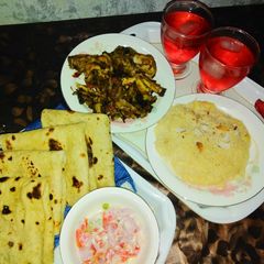 A picture of Chicken karaily and sheer khurma with rooti salad and drink.