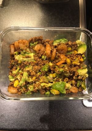 A picture of King prawns on lentils and pistachios with avocado.