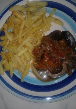 Una foto de Osobuco al vino tinto con papas fritas