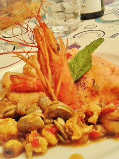 Una foto de Trucha asalmonada con guarnición de gambas y verduras
