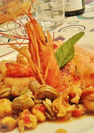 Una foto de Trucha asalmonada con guarnición de gambas y verduras