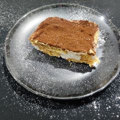 A picture of Tiramisu with whipping cream.