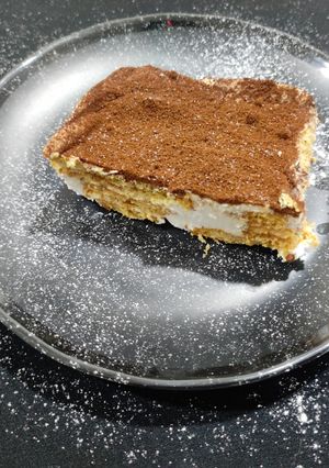 A picture of Tiramisu with whipping cream.
