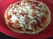 Una foto de pizza de pollo desmenuzado