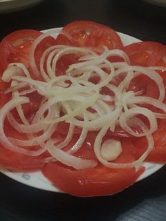 Una foto de Ensalada d tomate con cebollas.