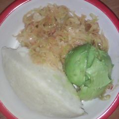 A picture of Ugali served with cabbage and avocado.