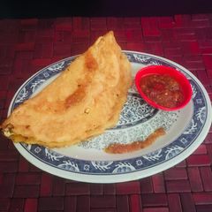 A picture of Moong Dal Chilla with Tomato chutney.