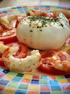 Una foto de Burrata con tomate y langostinos en su salsa
