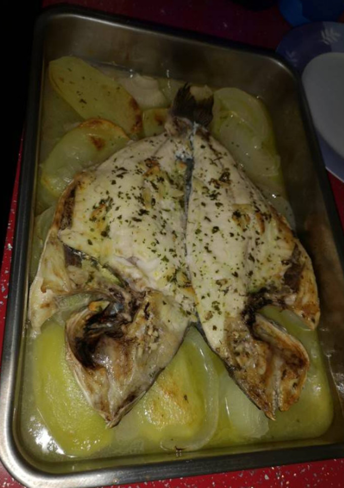 Una foto de Dorada al horno con patatas y cebolla