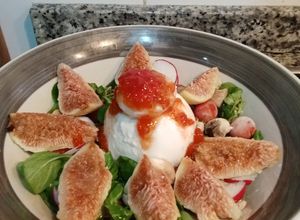 Una foto de Ensalada de canónigos, tomates cherry, higos y burrata con confitura de tomate casera