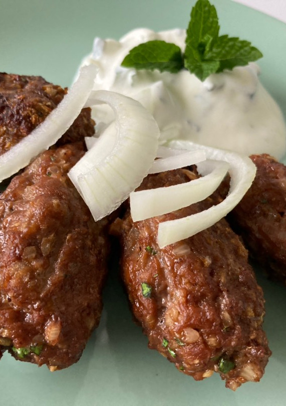 Una foto de Ćevapčićis con salsa tzatziki
